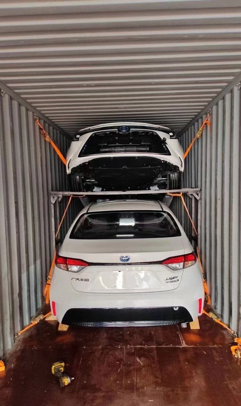 Sedans loaded on two levels inside a container using a racking frame